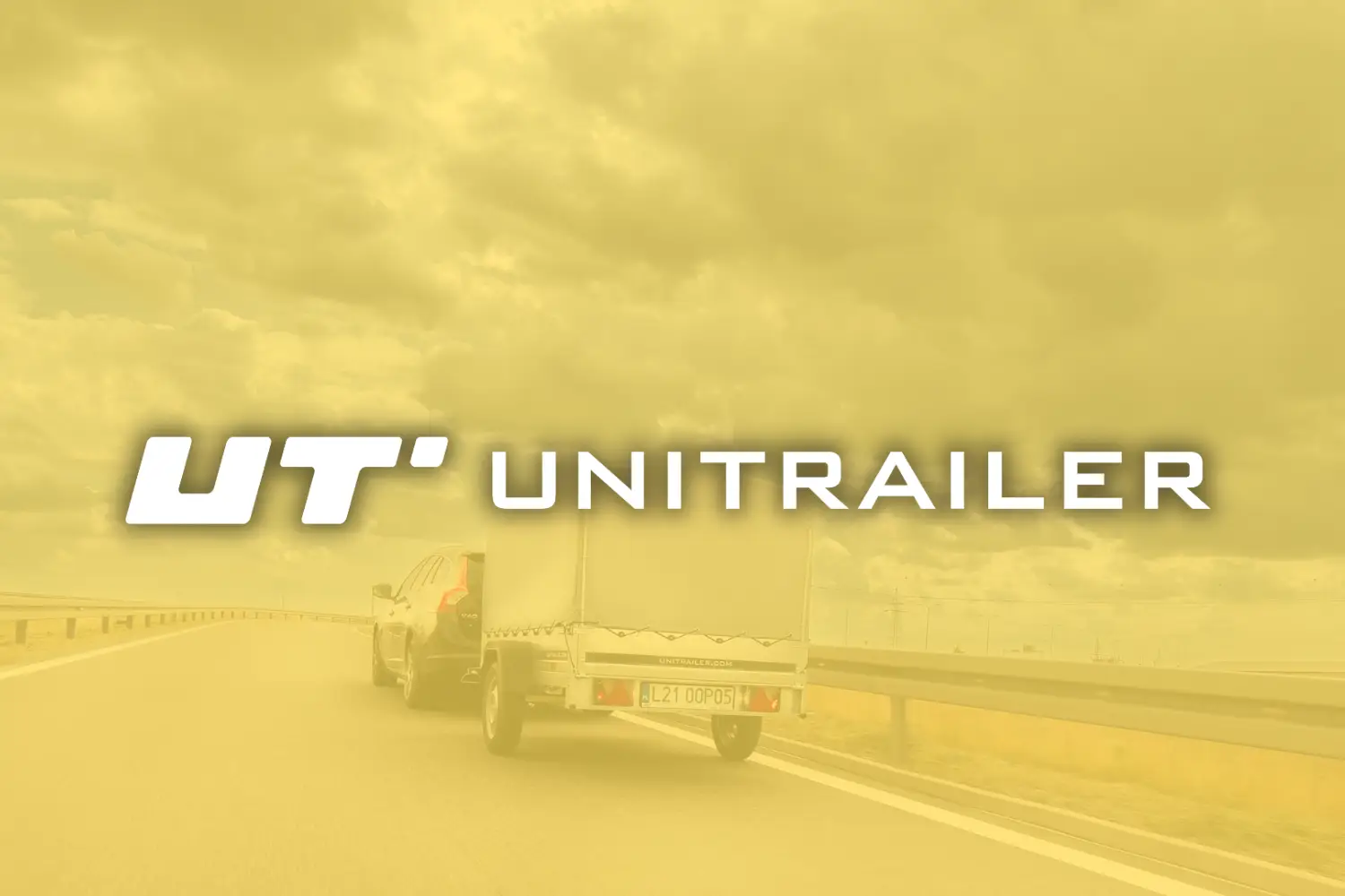 Een auto met een aanhangwagen rijdt over een snelweg onder een bewolkte hemel, met het logo en de tekst "UT UNITRAILER" op de voorgrond.